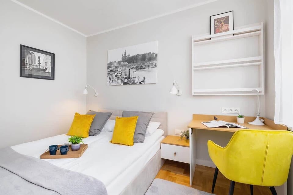 A bright living room with a grey sofa, yellow accents, and a minimalist decor style, maintaining a cozy and modern living area.






