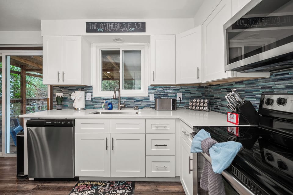 Bright modern kitchen with stainless appliances and stylish blue backsplash