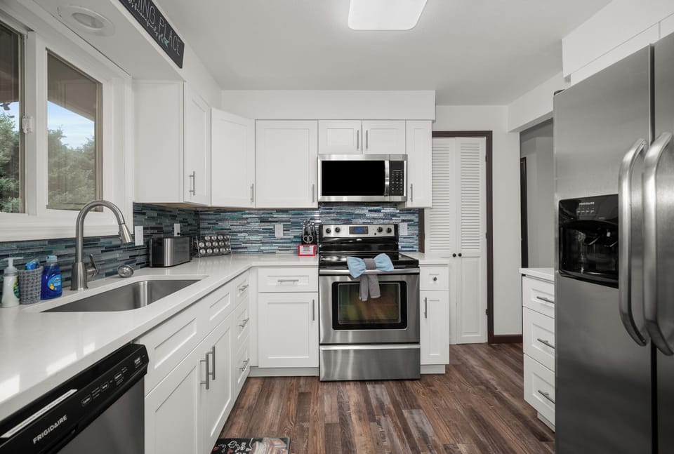 Bright modern kitchen with stainless appliances and stylish tile backsplash