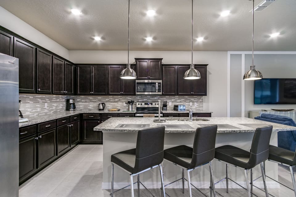 Fully equipped kitchen showing breakfast bar and seating