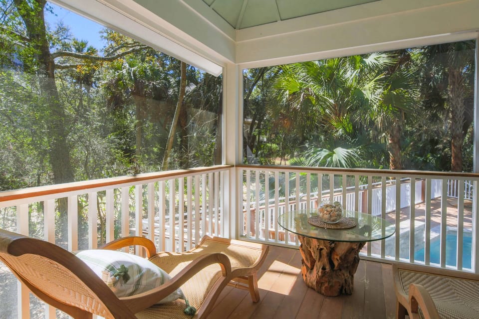 The primary suite leads out to the screened porch that overlooks the pool.