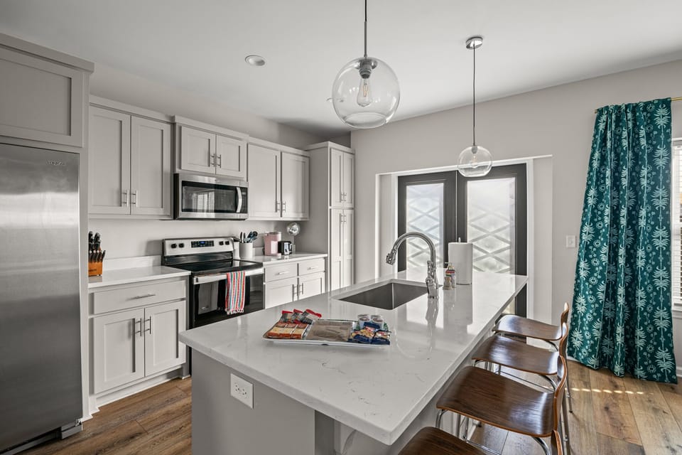 Fully stocked kitchen with quartz countertops and stainless steel appliances