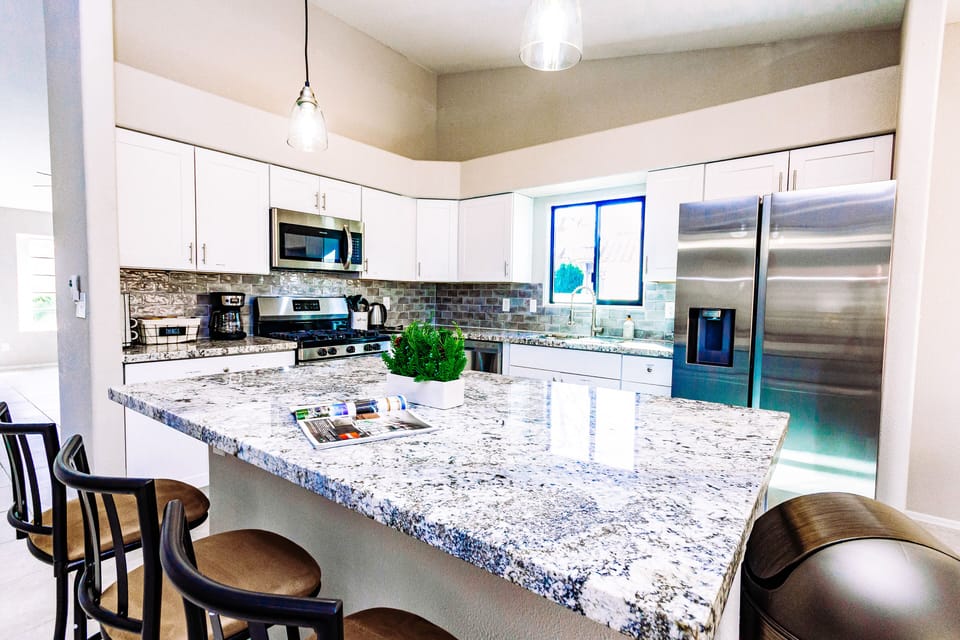 Modern kitchen is fully stocked and furnished with stainless steel appliance