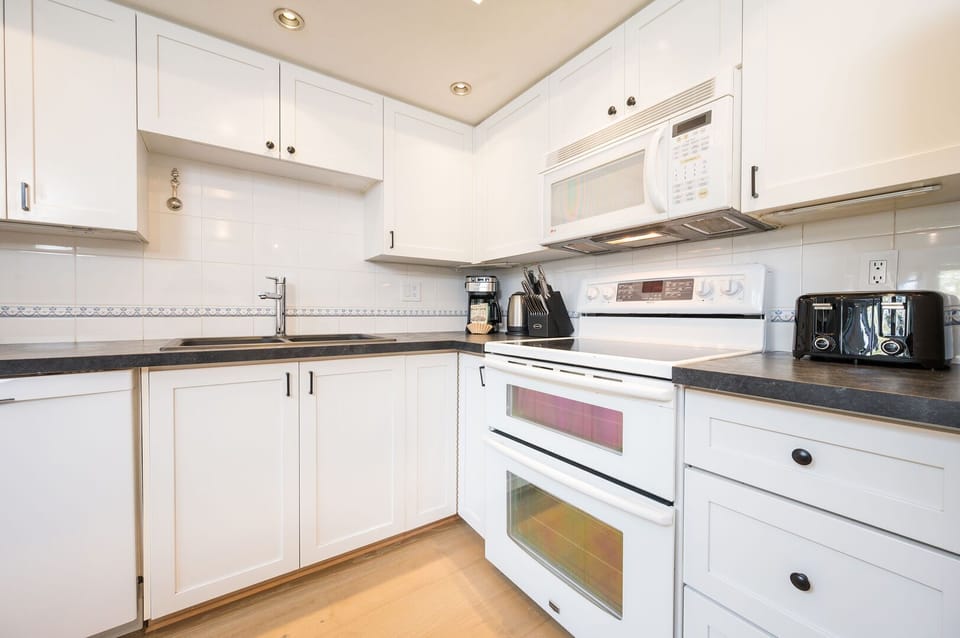 The kitchen boasts sleek cabinetry, stainless steel appliances, and ample counter space.