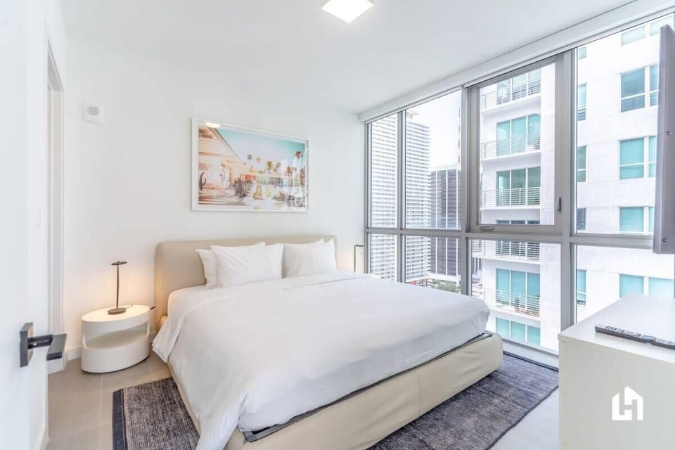 Wake up to natural light in this bedroom, with large windows and a king bed.