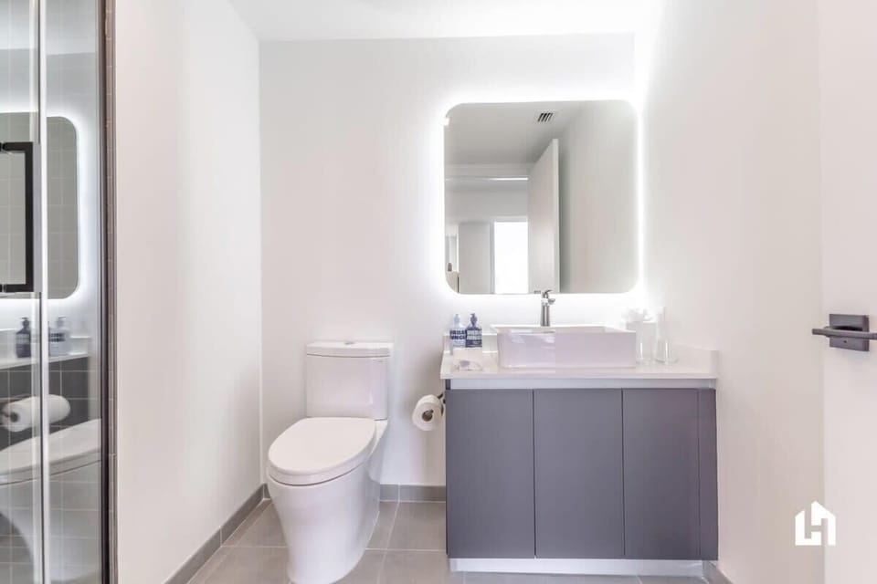 Modern bathroom with a sleek vanity and illuminated mirror.