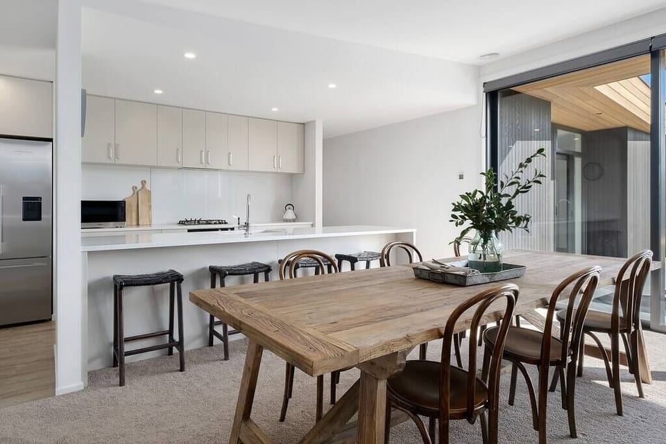 Rustic dining table next to kitchen.