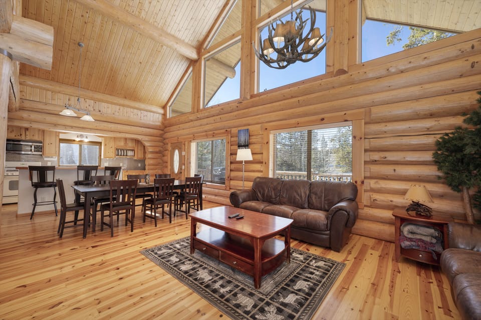 - Spacious cabin living area with rustic wooden beams   - Comfortable seating with mountain inspired décor   - Gather with loved ones in warm inviting cabin space