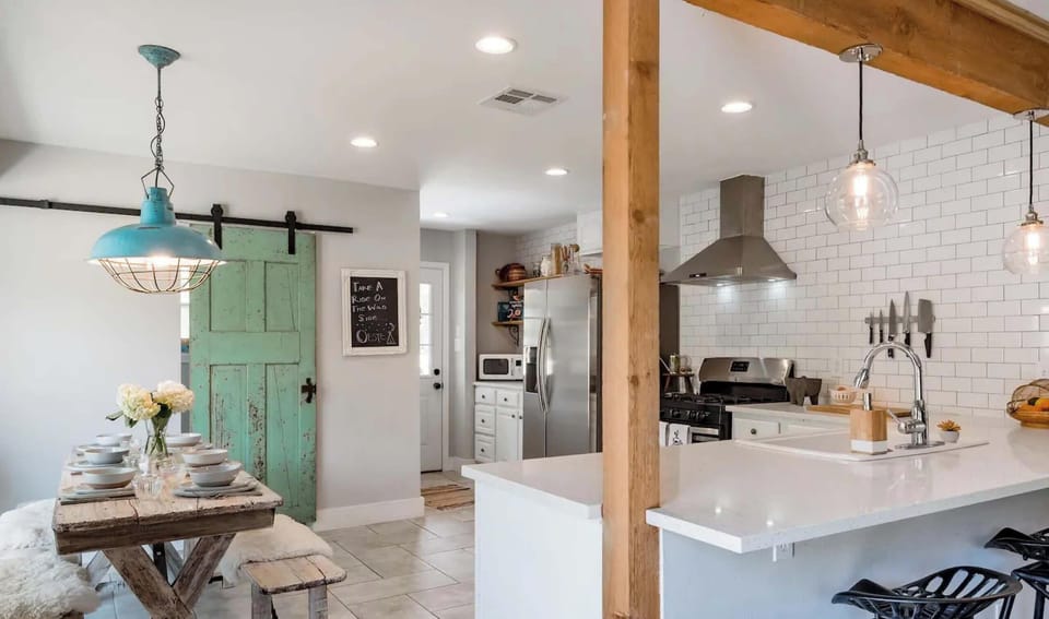 The kitchen has a bar and dining table for eating.