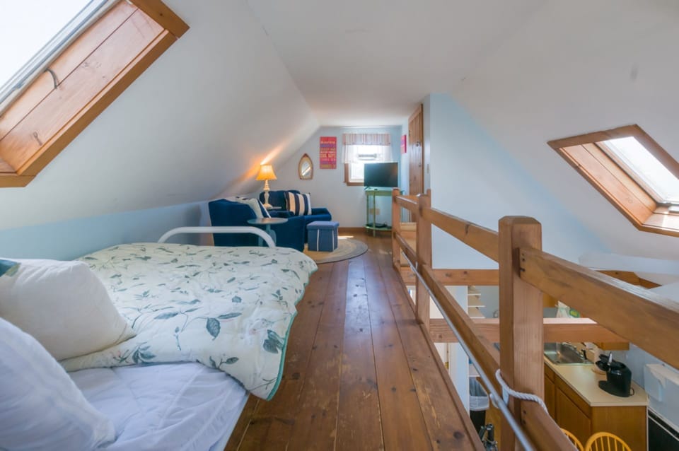 Loft area with futon, seating area and AC.