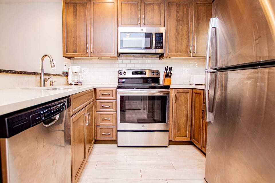 Kitchen area with all stainless steel appliances - microwave, dishwasher, range & refrigerator!
