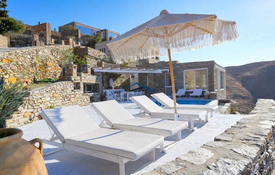 The patio with sunbeds, a BBQ, a large shaded dining area