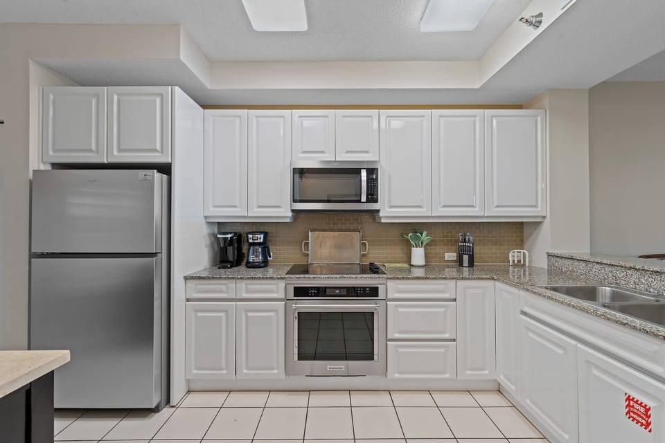 Beach Colony T15B- Your fully equipped kitchen has everything you need to prepare delicious meals. Crisp white cabinetry, stainless steel appliances, and ample counter space create a bright, functional cooking area.