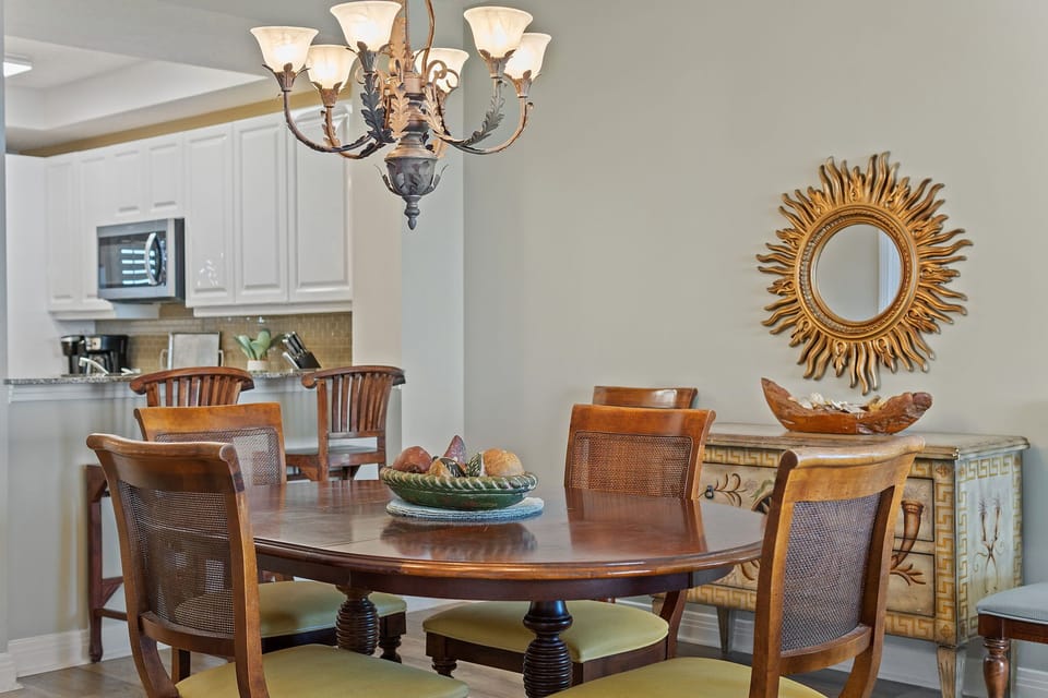 Step into your dining room where warm wood tones and elegant fixtures set the scene for shared meals. The kitchen stands ready nearby, making entertaining effortless.