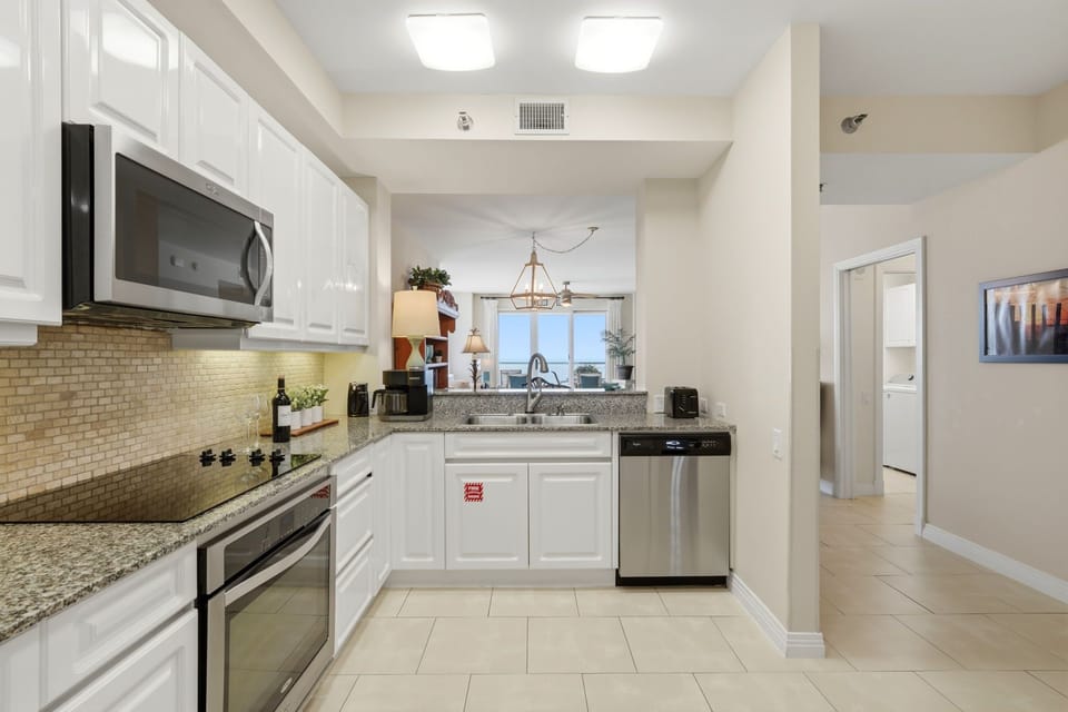 Beach Colony Tower PH1B - Your fully equipped kitchen features granite counters, stainless appliances, and stylish backsplash—perfect for preparing home-cooked meals during your stay.