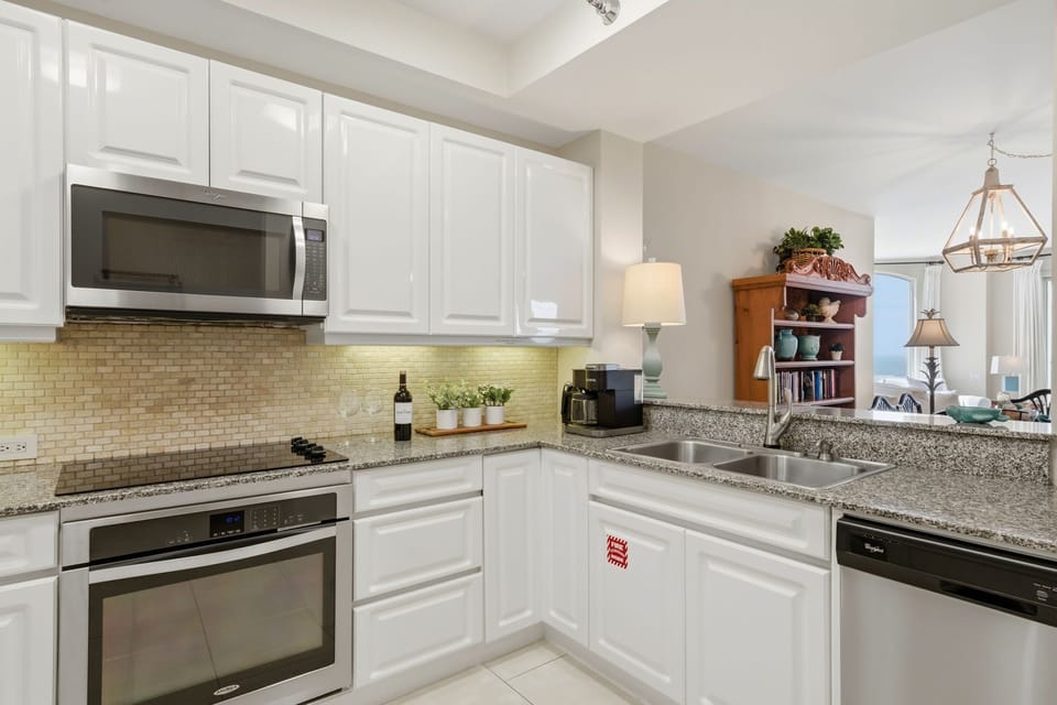 Beach Colony Tower PH1B -Your fully-equipped kitchen features modern stainless steel appliances, granite counters, crisp white cabinetry, and everything you need to prepare delicious home-cooked meals during your stay.