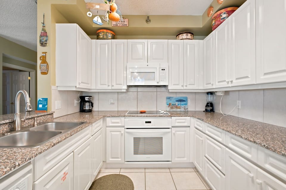 Beach Colony W13A- Your fully equipped kitchen invites you to prepare favorite meals with ample counter space, modern appliances, and a cheerful, homey feel that welcomes gatherings.
