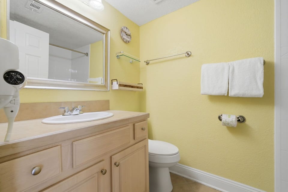 Ocean Breeze E601-Step into your private bathroom with warm yellow walls, fresh white towels, and a welcoming vanity with plenty of storage for your belongings.