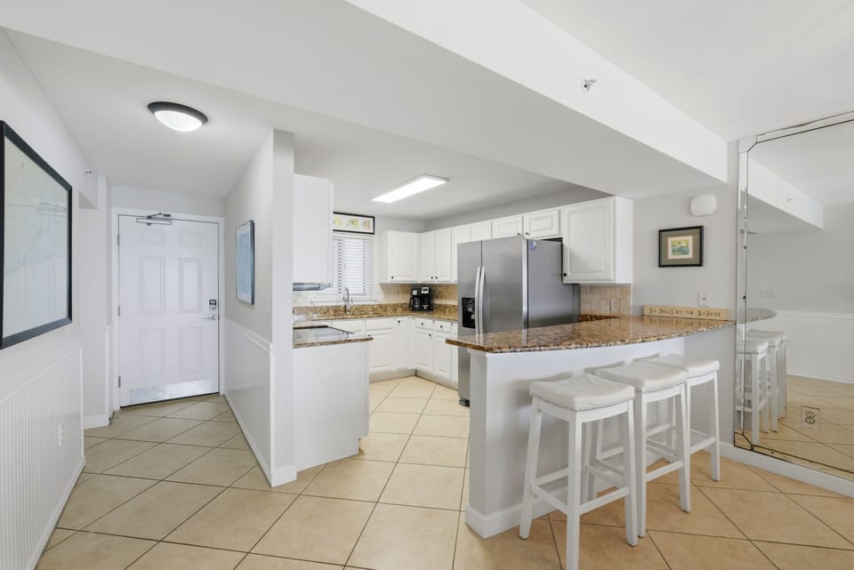 Sandy Key 318- You'll love preparing meals in this bright, spacious kitchen featuring granite countertops, modern stainless appliances, and a welcoming breakfast bar perfect for morning coffee or casual dining with family.