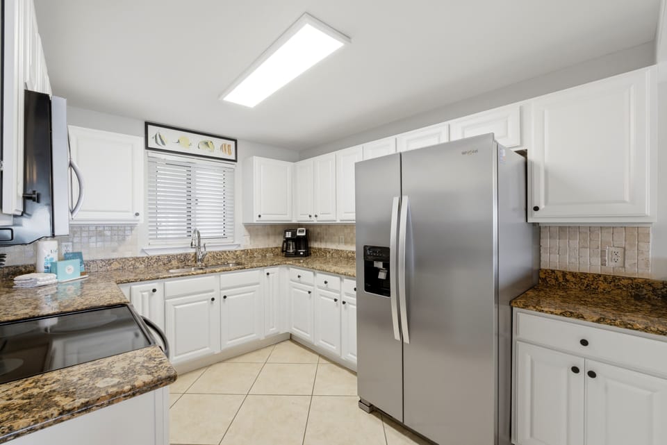 Sandy Key 318- You'll love preparing meals in this bright, fully equipped kitchen with granite countertops, stainless appliances, and plenty of storage space for all your cooking needs.