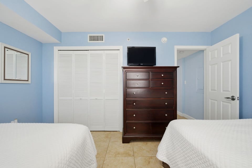 Sandy Key 637- Relax in this peaceful bedroom with two plush beds, ample storage, and climate-controlled comfort—your restful retreat awaits after a day of exploring.