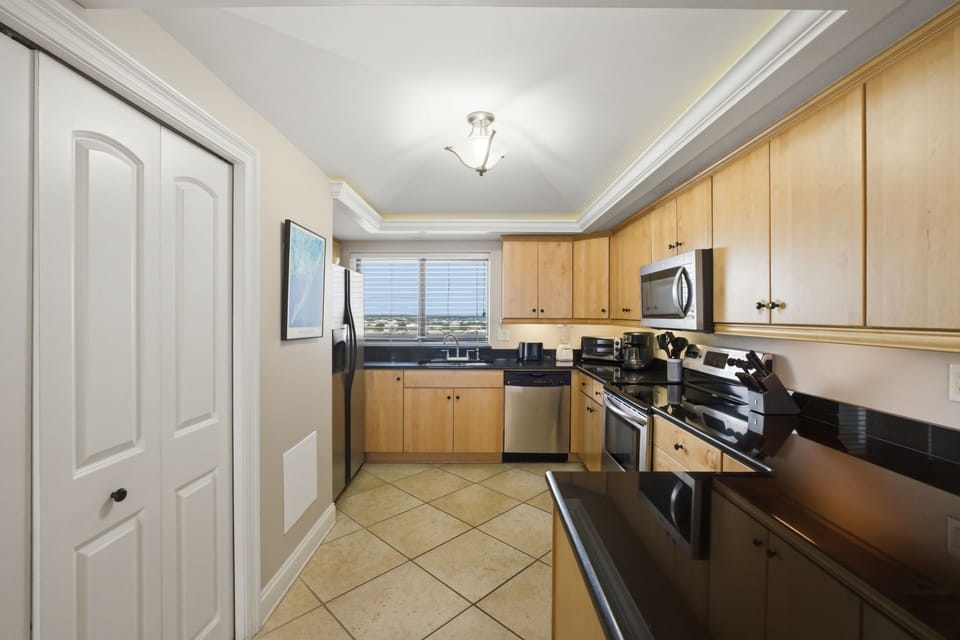 Shipwatch D803- Step into your fully-equipped kitchen with modern stainless steel appliances and warm wood cabinetry, where you can whip up meals while soaking in natural light and scenic views through the window.