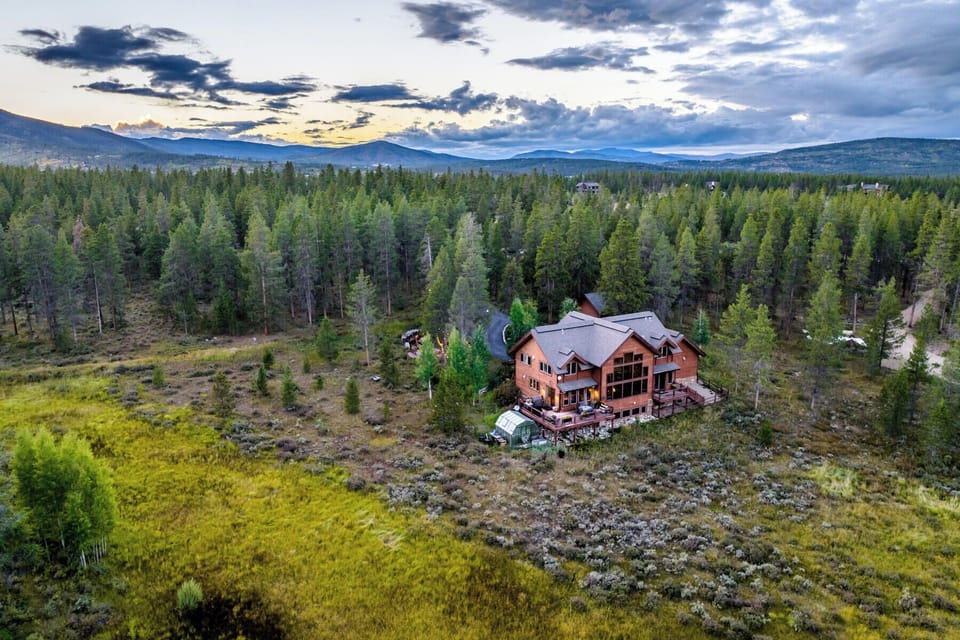 Secluded mountain lodge nestled in forested wilderness with sweeping alpine views.