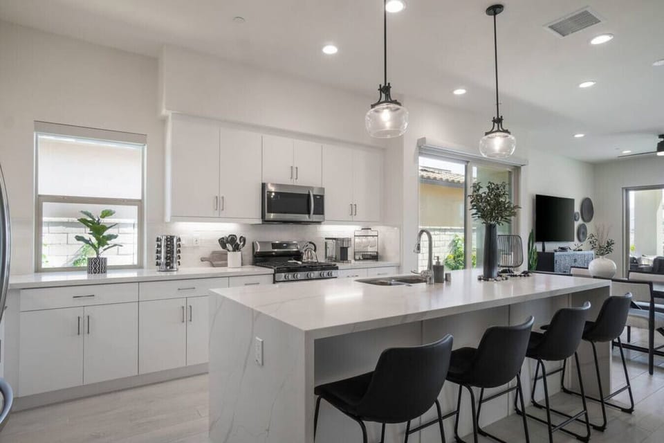Bright chef’s kitchen w/ large island, bar seating & sleek stainless appliances