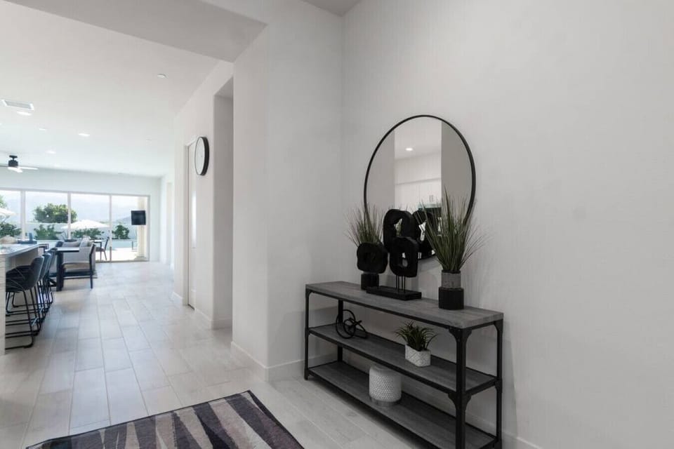 Welcoming entry hall w/ statement mirror table & view into the open-concept living space