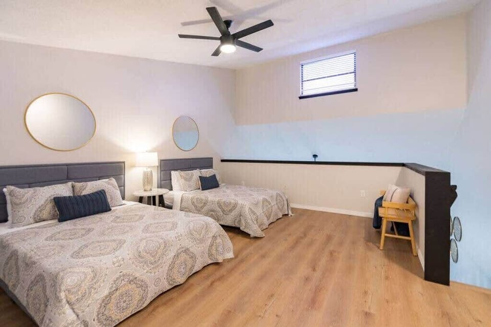 Spacious loft bedroom with two queen beds and modern decor.
