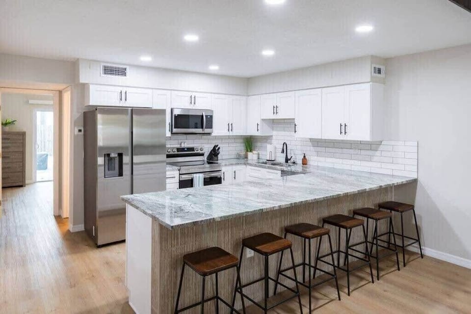 Modern kitchen with a large marble island and stainless steel appliances