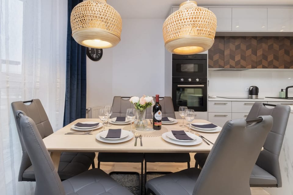 A dining table with modern chairs and elegant lighting, perfect for shared meals.