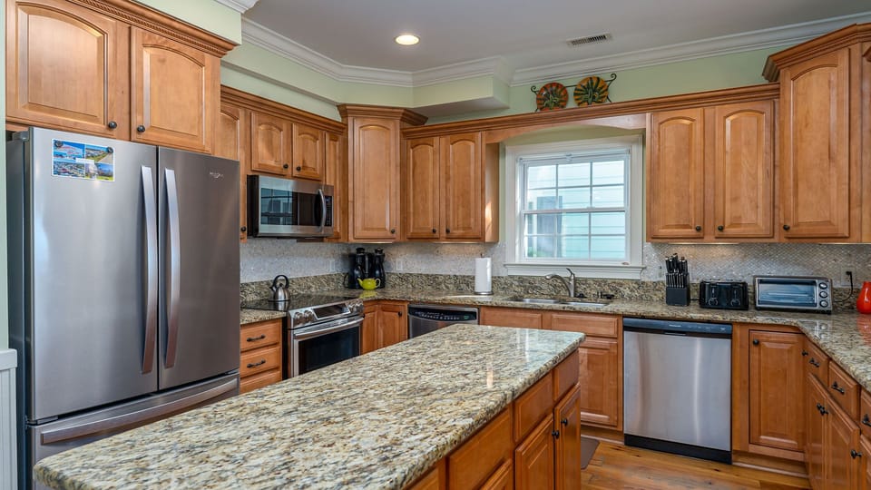 Your spacious kitchen awaits with granite countertops, warm wood cabinets, and modern stainless appliances—perfect for creating memorable meals together.