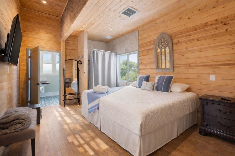 Private Bedroom with Wood Interior, Comfortable Bed, Smart TV, and Natural Light — Warm, Quiet, and Designed for Rest

