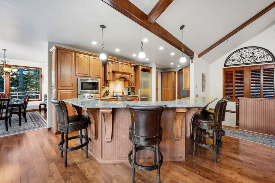 Your gourmet kitchen invites culinary adventures with its spacious island, premium appliances, and warm wood finishes creating the perfect gathering spot.