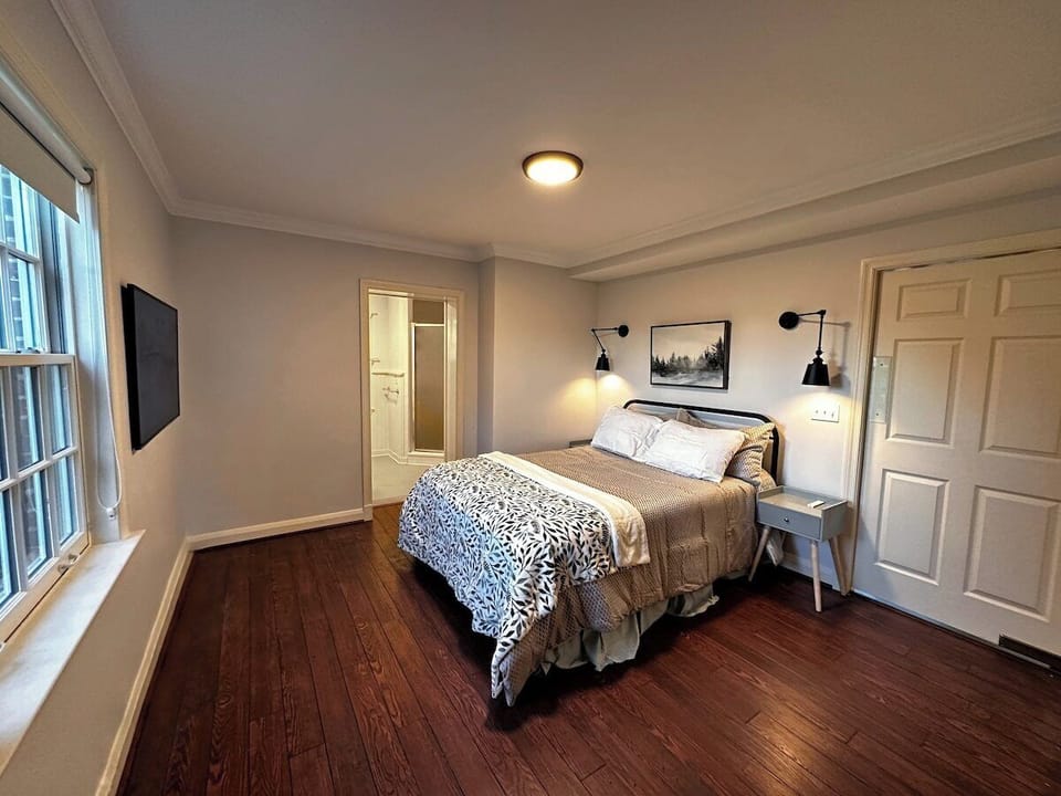 First Floor Bedroom, with attached bathroom, smart-tv, reading lights, and closet.