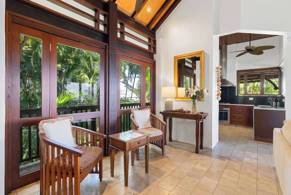 Enjoy a peaceful pause in the living area, where additional seating captures leafy outlooks and creates another inviting corner to unwind.