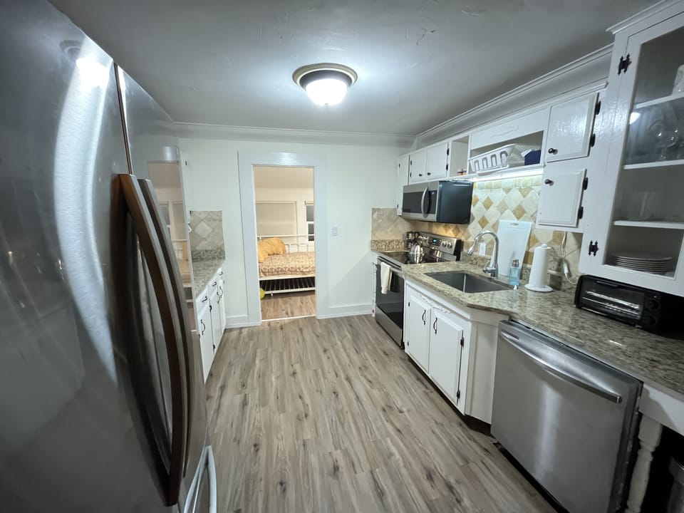Kitchen looking towards back porch with a full sized bed.