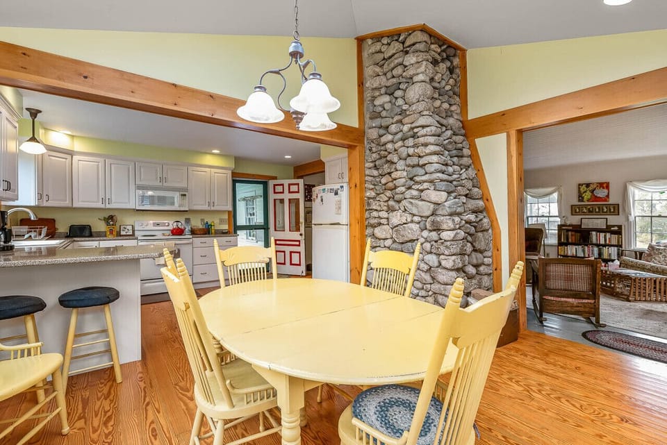 Open concept kitchen, dining, and living room with beautiful stone fireplace