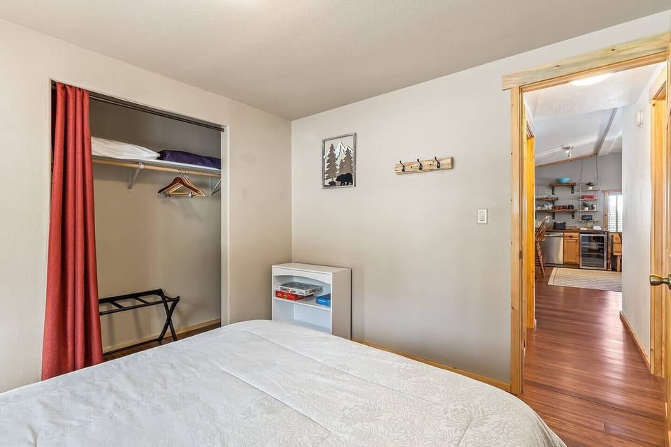 A sneak peek into the heart of the home - the view from the second bedroom down the hall showcases the inviting kitchen and living room, creating a sense of connection and warmth throughout the living space.