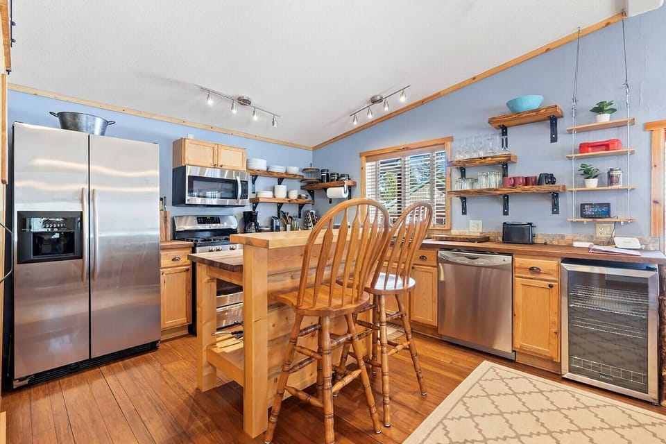 Stainless steel appliances shine in this contemporary kitchen, accented by an island built for two, offering a stylish yet cozy setting for cooking and companionship.