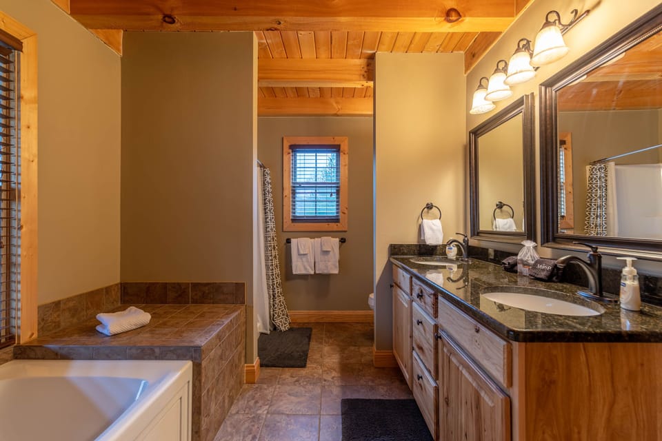 Soak away the day in the tile-surround tub, then freshen up at the spacious double vanity. Rustic wood beams keep the mountain cabin feel going.