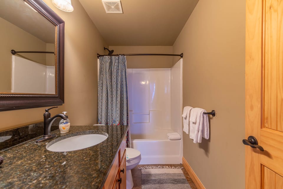 A clean, well-appointed full bath at Mayapple Ridge, stocked with fresh towels and ready for your arrival.
