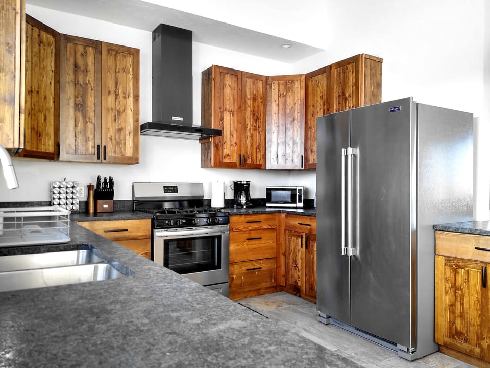 This home's kitchen features granite and stainless steel, with all appliances
