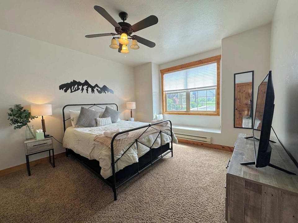 The master bedroom has a queen bed, a terrific window seat,  a TV, and an en suite bath.