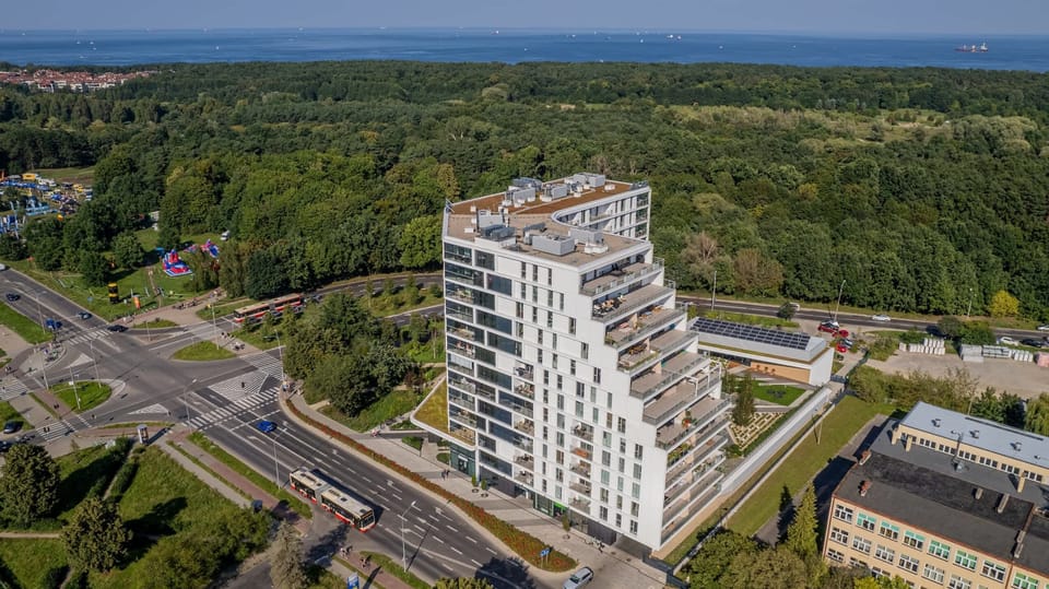An aerial view of the residential complex surrounded by a lush forest.