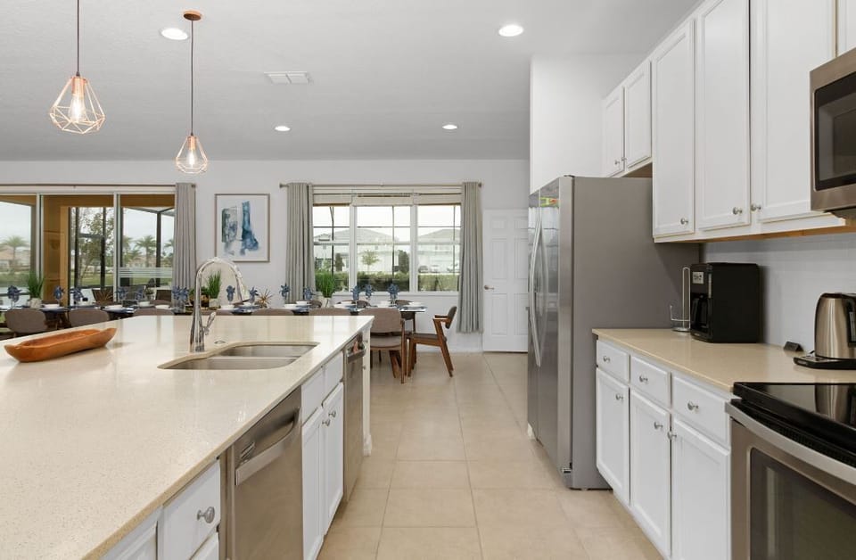 Kitchen view towards large dining area and outdoor, screened private pool