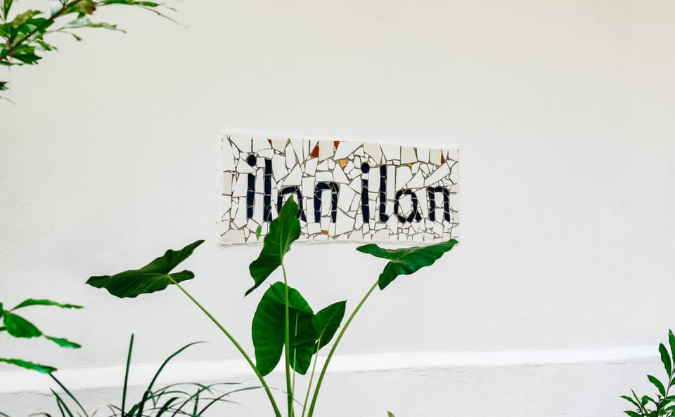 Welcome sign at the villa entrance, surrounded by tropical greenery
