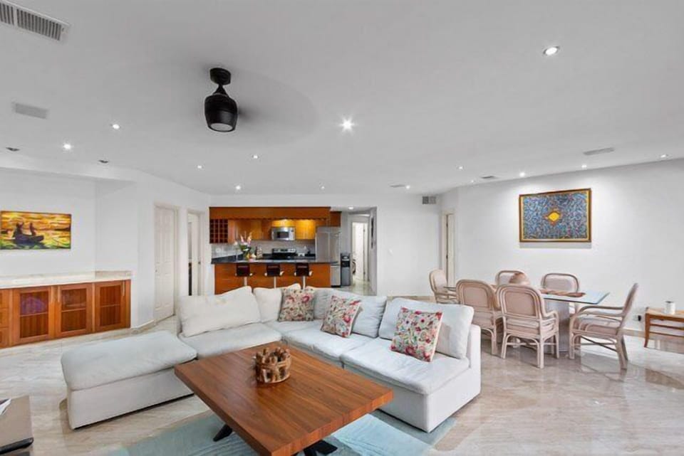 The living room has a comfortable l-shaped couch, ocean views, and a flat-screen TV