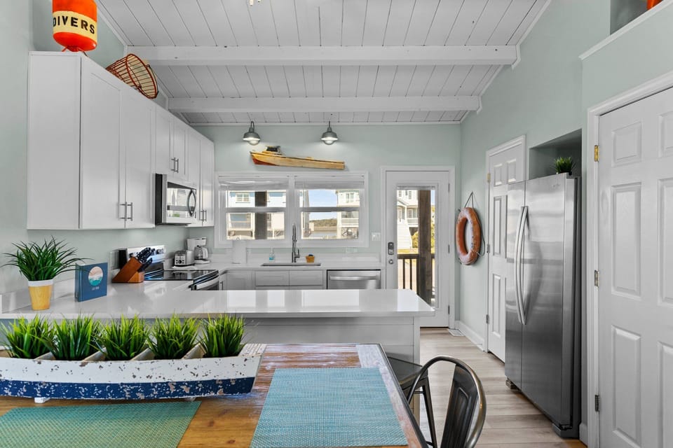 Dining table and kitchen with quarts counterrops.